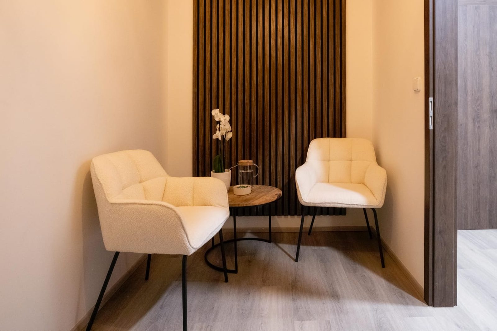 Dvě křesílka a orchidej v čekárně salonu
